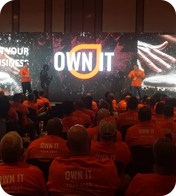 Speakers presenting on stage at an OWN IT live event.